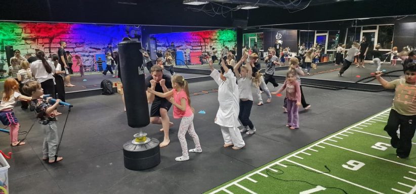 Bunte Fitnessklasse mit vielen Teilnehmern in einem modernen Trainingsraum.